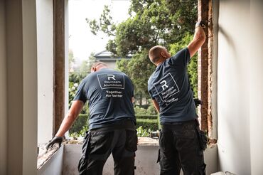 Dois instaladores da Reynaers Aluminium a desmontar janelas antigas no local.