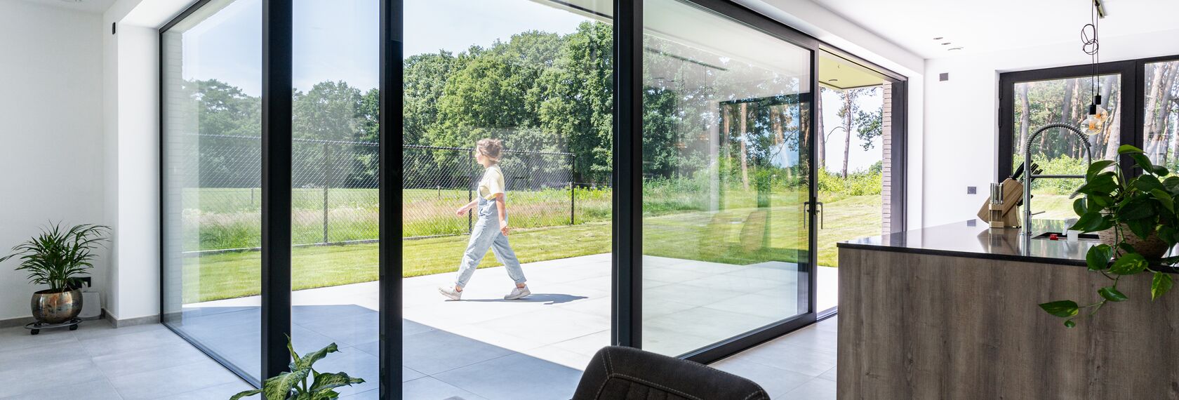 MasterPatio sliding system in modern home with grass lawn.