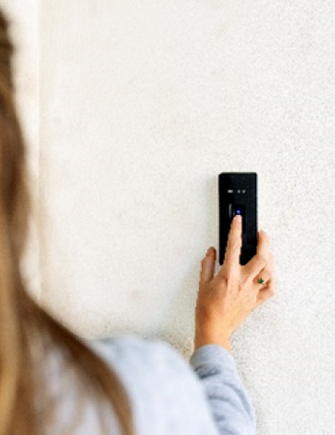 A girl using a fingerprint scan to open door demonstrating access controls