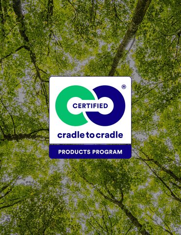 Logótipo Cradle to Cradle em frente às copas das árvores verdes.