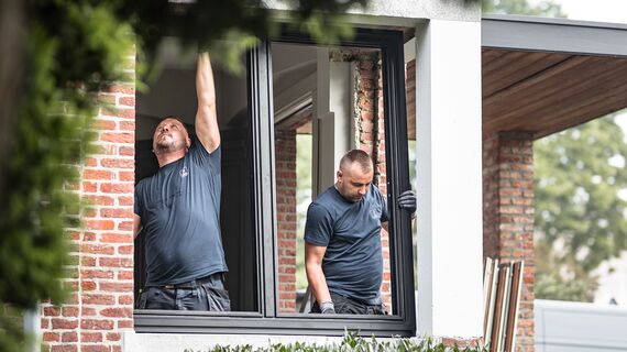 Dois instaladores colocam Perfis de alumínio novos numa casa renovada.